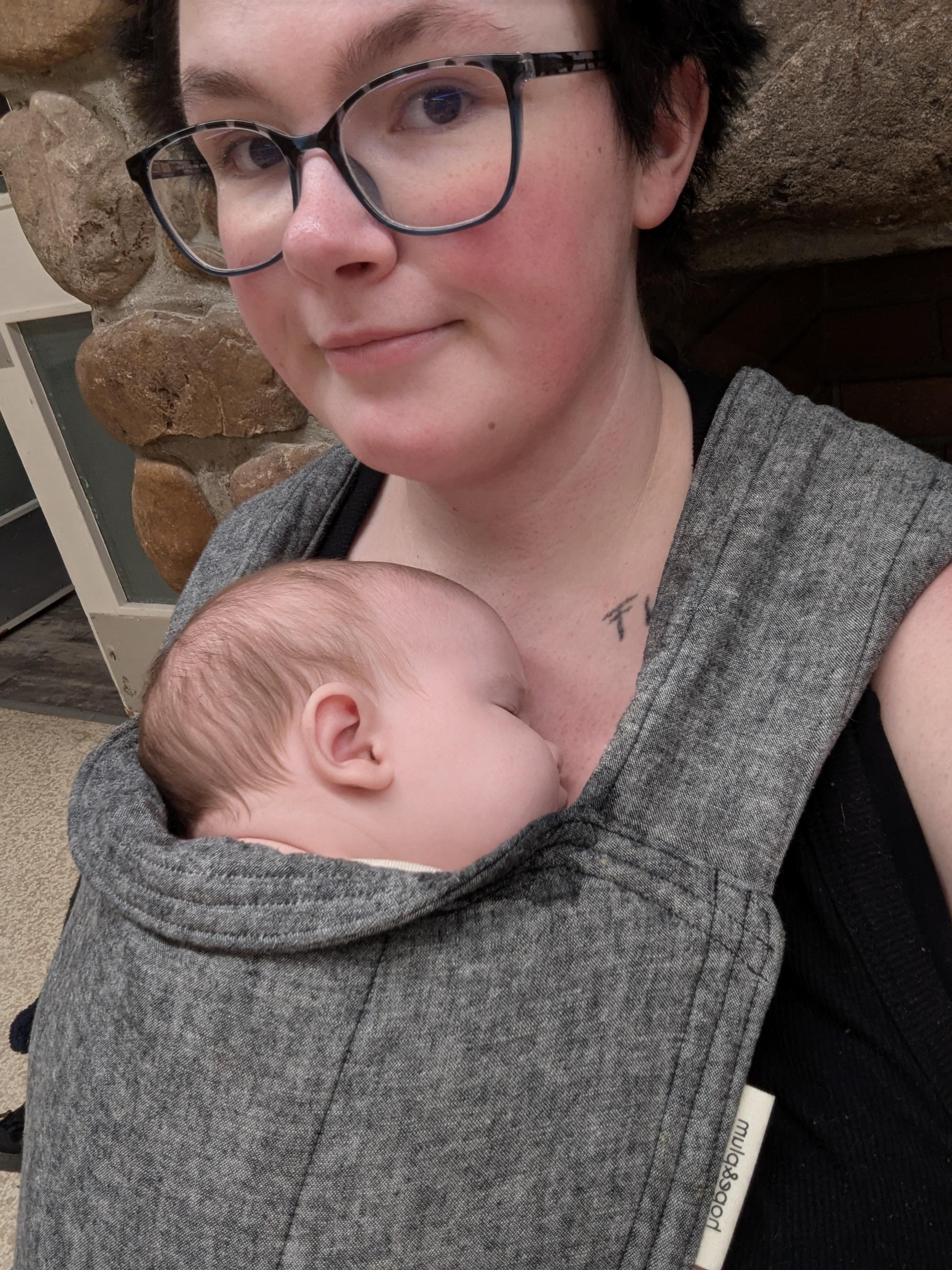 Parent with a large chest comfortably wearing a hope&plum Lark Baby Carrier with their baby